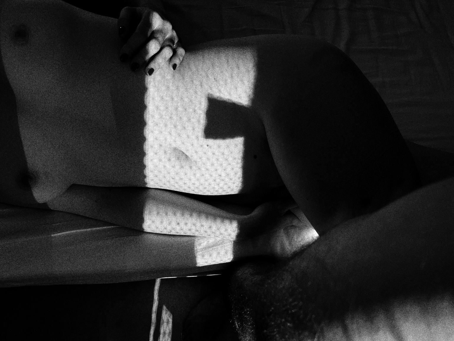 Geometric morning light and shadow fall across a reclining figure.
